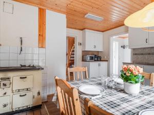 a kitchen with a table and chairs and a kitchen with white cabinets at Holiday Home Mörtefors by Interhome in Virserum +15 photos