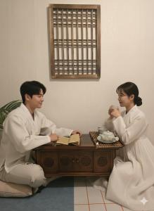 a man and a woman sitting at a coffee table at Slow accommodation,Free parking,kspo dome,Kangdong Sacred Heart Hospital,Seoul Asan Hospital,COEX,Lotte World Tower,kspo in Seoul