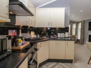 una cucina con mobili bianchi e ripiani neri di 32 Grasmere a Troutbeck Bridge