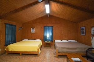 コンカンにあるCypress Villa 5の木製の壁の部屋にベッドが2つある