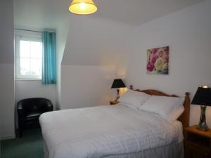 a bedroom with a bed and a chair and a window at Holiday Home Ballybunion - TR4 HC NO 4 by Interhome in Ballybunion