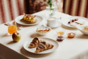 a table with plates of breakfast food on it at Hotel Colbricon in San Martino di Castrozza