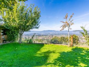 a yard with green grass and a fence with a view at Holiday Home La Sosta di Fano by Interhome in Reggello
