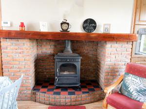 d'une cheminée en briques avec une cuisinière. dans l'établissement Holiday Home Lisheenbawn Farmhouse Farranfore by Interhome, à Castleisland