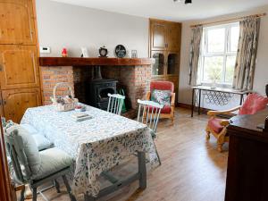 un salon avec une table et une cheminée dans l'établissement Holiday Home Lisheenbawn Farmhouse Farranfore by Interhome, à Castleisland