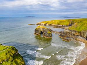 a rock formation in the water near a beach at Holiday Home Ballybunion - TR4 HC No 27 by Interhome in Ballybunion