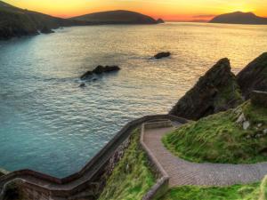 a stairway leading into a body of water with a sunset at Holiday Home Dingle Bay View - TR2 by Interhome in Emlagh East