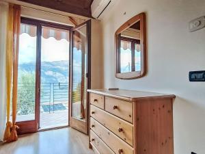 a bedroom with a dresser and a large window at Villa Graziella by Interhome in Malcesine