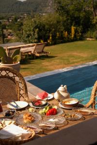 a table with food on it next to a pool at Kassandra Heritage in Fethiye
