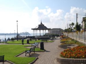 Holiday Home Castlemartyr Lodges - TR4 No 1 - 3 Bed by Interhome في كاستلمارتير: حديقة بها شرفة ومقاعد وأزهار