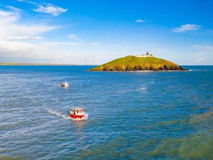 Holiday Home Castlemartyr Lodges - TR4 No 1 - 3 Bed by Interhome في كاستلمارتير: يوجد مركبين في كمية كبيرة من المياه مع جزيرة