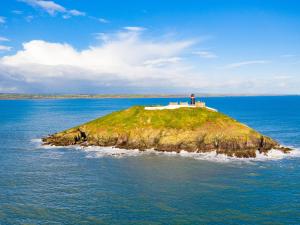 Holiday Home Castlemartyr Lodges - TR4 No 1 - 3 Bed by Interhome في كاستلمارتير: جزيرة صغيرة في الماء مع رجل عليها