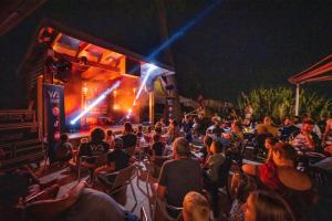 a crowd of people sitting in chairs watching a stage at Camping Les Pins de la Coubre in Les Mathes