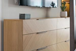 eine Küche mit Holzschubladen und einem Fernseher an der Wand in der Unterkunft Luxury Furnished Apartments by Hyatus Boston South Bay in Boston + 42 Fotos