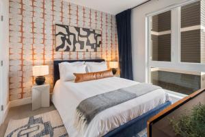 ein Schlafzimmer mit einem Bett und zwei Lampen und einem Fenster in der Unterkunft Luxury Furnished Apartments by Hyatus Boston South Bay in Boston