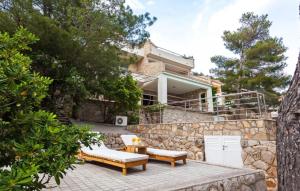 une maison avec deux bancs et un mur de pierre dans l'établissement Waterfront Villa Dora by Villas Guide, à Prižba