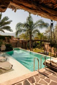a swimming pool with palm trees in the background at Kassandra Heritage in Oludeniz