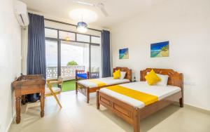 a bedroom with two beds and a desk and a window at Elna's Baobab Waves - 2BR and 3BR Beachfront Nyali in Mombasa +98 photos