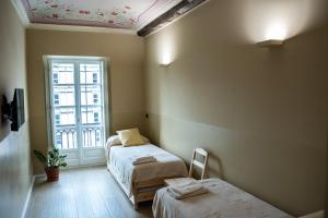a small room with two beds and a window at Top Rooms Torino in Turin