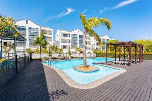 Una piscina con una palmera delante de un edificio. en The Sandown 178 by CTHA, en Parklands