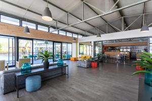 un vestíbulo de oficina con mesas, sillas y ventanas en The Sandown 178 by CTHA, en Parklands