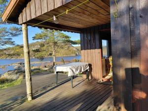a wooden porch with a table on the deck at 5 person holiday home in FARSUND-By Traum in Helle +14 photos