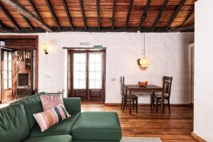 ein Wohnzimmer mit einer grünen Couch und einem Tisch in der Unterkunft Finca El Ingeniero by Huskalia in San Pedro