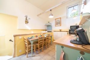 a kitchen with a table and chairs in a room at Le Baiser du Soleil - Piscine Privée in Mirabel-aux-Baronnies