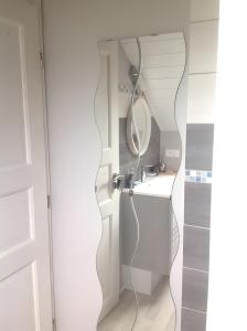een badkamer met een spiegel en een wastafel bij Les Hirondelles du Cap in Besnard
