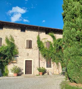 ein großes Backsteingebäude mit einer Tür und einem Baum in der Unterkunft Antico N19 in Passirano