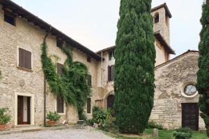 an ivy covered building with a clock on the side at Antico N19 in Passirano