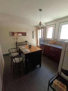 a kitchen with a table and chairs and a sink at La parenthèse ardéchoise in Le Pouzin