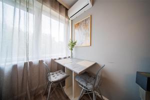 Una mesa y sillas en una habitación con ventana. en Flex SelfCheckIns 192 - Zagreb - Studio Apartment - New, en Zagreb
