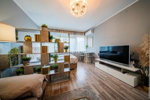 Una sala de estar con un televisor grande y una habitación con una cama. en Flex SelfCheckIns 192 - Zagreb - Studio Apartment - New, en Zagreb