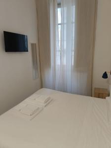 a white bed in a room with a window at Residence e appartamenti Rosaroll in Naples