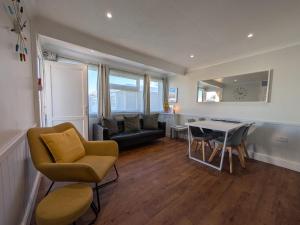 a living room with a couch and a table at Beachcomber, Two bed Chalet on Sunbeach Holiday Park - Sleeps 4, pet friendly, FREE pool and entertainment passes included - plus WiFi - only 300m from the beach! in Scratby