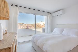 een slaapkamer met een wit bed en een groot raam bij Villa aux Goudes in Les Goudes