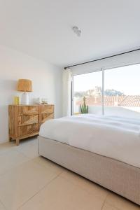 een slaapkamer met een groot bed en een groot raam bij Villa aux Goudes in Les Goudes