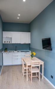 a kitchen with a wooden table with chairs and a sink at Top Rooms Torino in Turin +12 photos