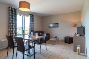 Les Thermes 421- Appt pour 4 avec piscine partagée في كونكارنو: غرفة طعام بها طاولة وكراسي