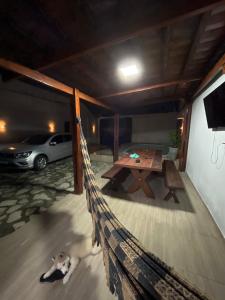 a hammock in a garage with a table and a car at Casa para repouso in Mamanguape