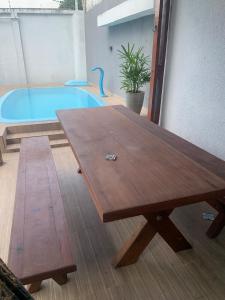 a wooden table in front of a swimming pool at Casa para repouso in Mamanguape