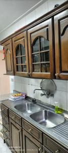 eine Küche mit Spüle und Holzschränken in der Unterkunft Alexandria Egypt in Alexandria