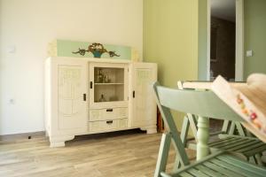 ein weißer Schrank in einem Raum mit einem Tisch und einem Stuhl in der Unterkunft Olive Coast Houses in Kyparissia