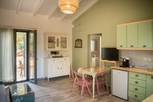 eine Küche mit grünen Schränken sowie einem Tisch und Stühlen in der Unterkunft Olive Coast Houses in Kyparissia