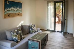 ein Wohnzimmer mit einem Sofa und einer Schachtel darauf in der Unterkunft Olive Coast Houses in Kyparissia + 16 Fotos