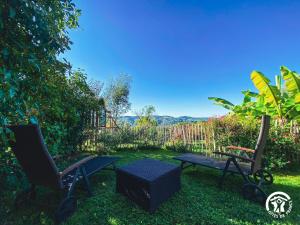 dos sillas y un banco en un patio en La Prunille, en Pruines