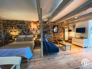 a bedroom with a bed and a blue chair at La Prunille in Pruines