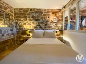 a bedroom with a large bed in a stone wall at La Prunille in Pruines