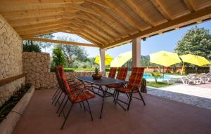 eine Terrasse mit einem Tisch, Stühlen und Sonnenschirmen in der Unterkunft Holiday home Ostojic by Villas Guide in Peračko Blato